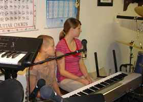Two students sit at a keyboard